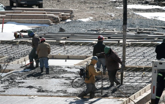 Men pouring wet concrete. Wireless temperature cure monitoring System.