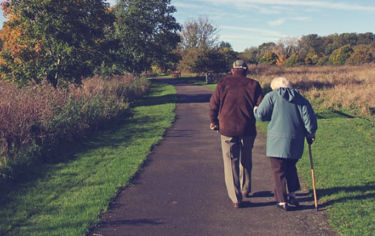 An elderly couple walking on a path. Monitor location of your senior loved ones.